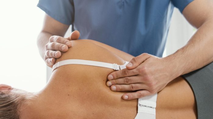 front-view-osteopathic-therapist-checking-female-patient-s-back